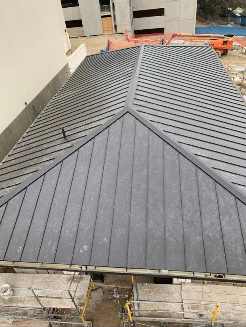 Commercial metal roof construction with crane equipment in Cottage Grove